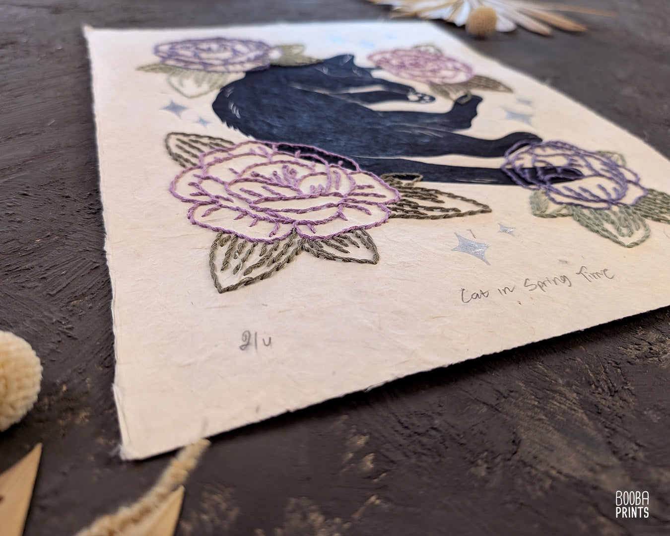 Original hand printed and hand embroidered linocut print. "Cat In Spring Time" is a linocut print, printed by hand, featuring a sleepy black cat, surrounded by  hand embroidered flowers and metallic stars. Print is available in 2 version. A unique original mixed media art piece for cat lovers. Beautiful special gift for your cat loving friend. Cat art wall by Booba Prints.