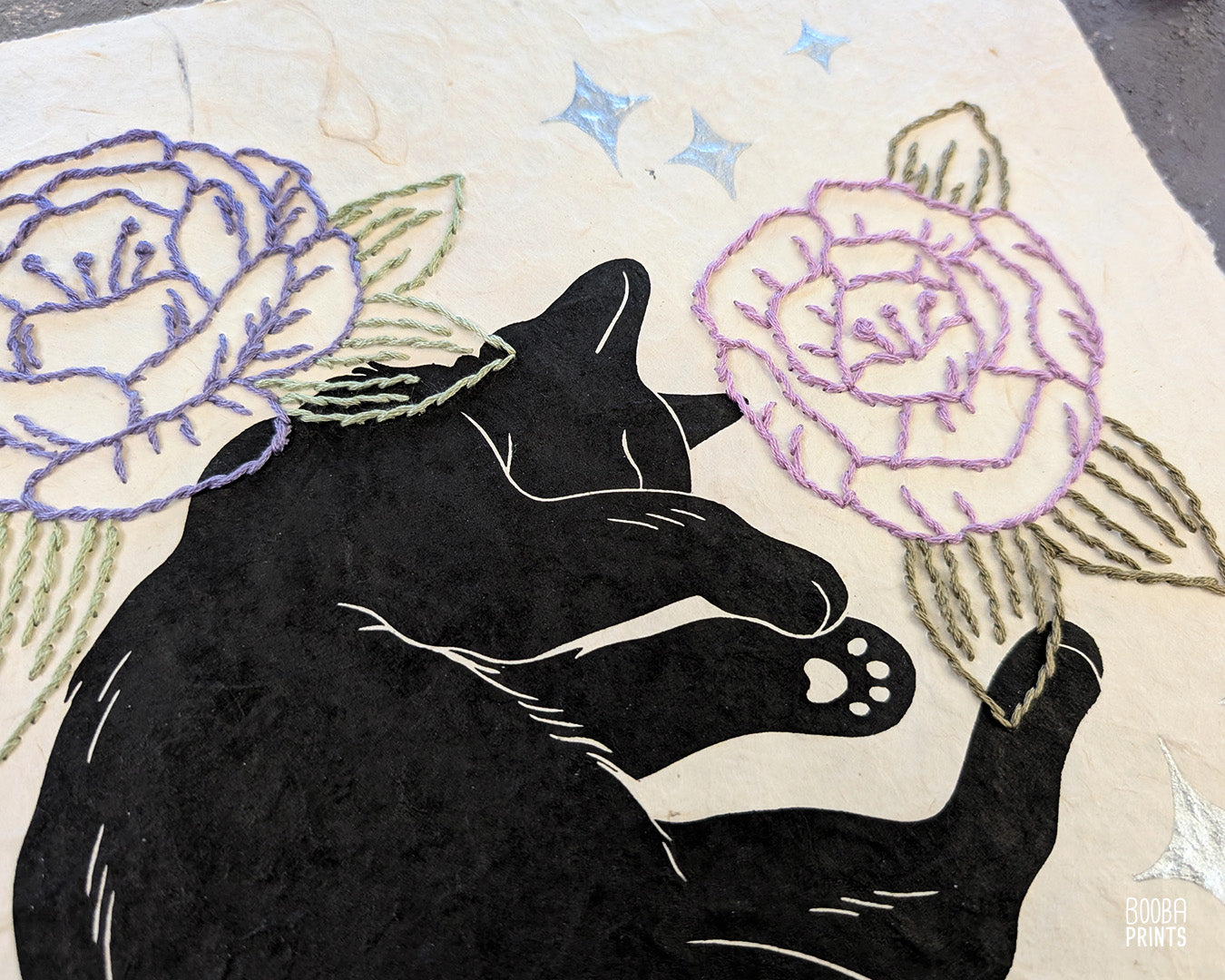 Original hand printed and hand embroidered linocut print. "Cat In Spring Time" is a linocut print, printed by hand, featuring a sleepy black cat, surrounded by  hand embroidered flowers and metallic stars. Print is available in 2 version. A unique original mixed media art piece for cat lovers. Beautiful special gift for your cat loving friend. Cat art wall by Booba Prints.