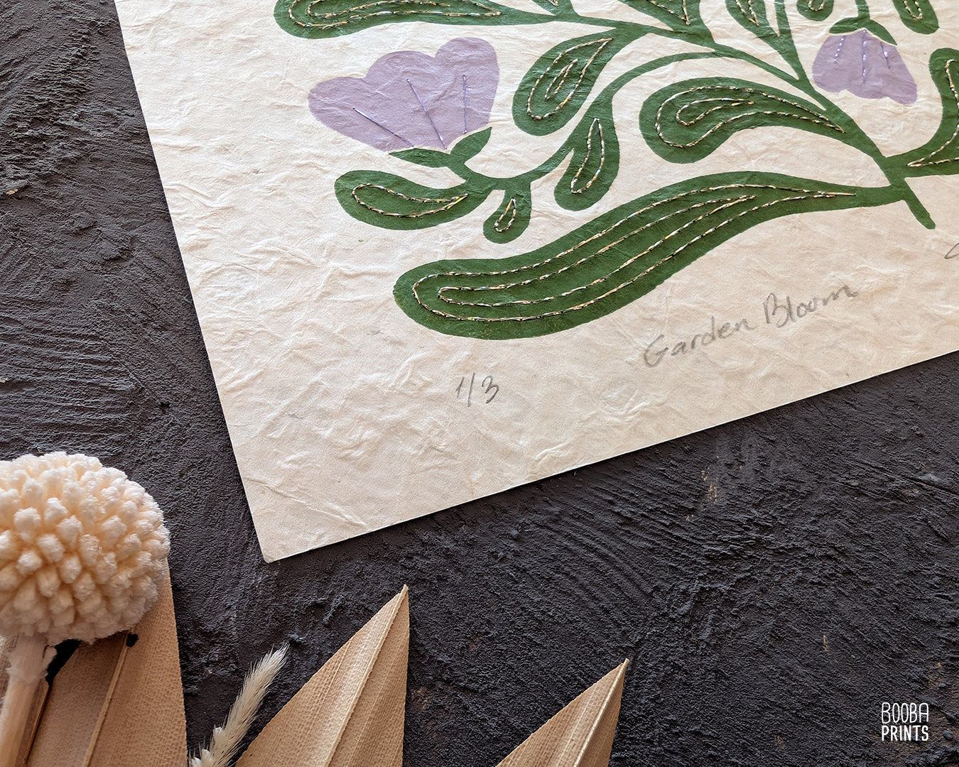 Close up on a handmade linocut and hand embroidered original linocut print. Details of hand embroidery with champagne and purple thread.