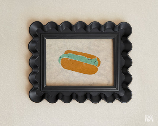 Original 2 color linocut print, printed in Ochre and mint green, showing a cute cat in a hot dog but. Cute whimsical art for your kitchen. Art by Booba Prints