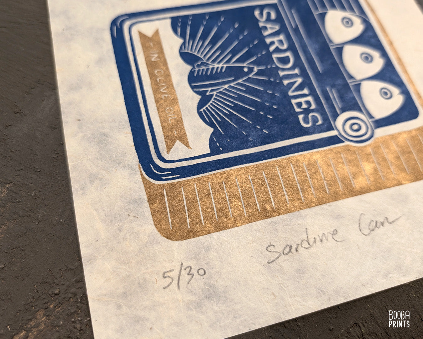 Original handmade linocut prints of Sardine Tin Can. Printed in blue and gold, using oil based ink on natural Lokta paper. Cute print for kitchen, stylized sardine print. Art by Booba Prints.