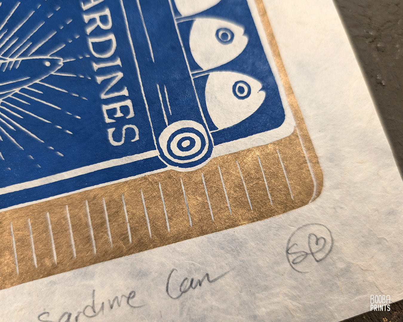 Original handmade linocut prints of Sardine Tin Can. Printed in blue and gold, using oil based ink on natural Lokta paper. Cute print for kitchen, stylized sardine print. Art by Booba Prints.