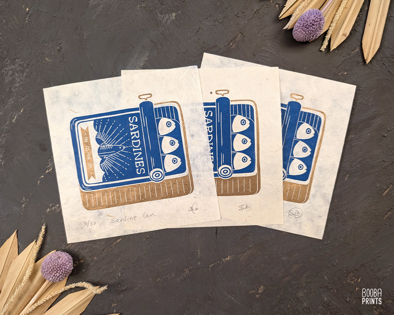 Original handmade linocut prints of Sardine Tin Can. Printed in blue and gold, using oil based ink on natural Lokta paper. Cute print for kitchen, stylized sardine print. Art by Booba Prints.