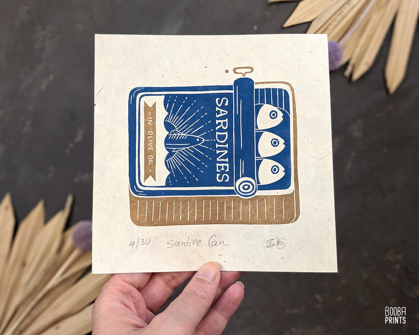 Original handmade linocut prints of Sardine Tin Can. Printed in blue and gold, using oil based ink on natural Lokta paper. Cute print for kitchen, stylized sardine print. Art by Booba Prints.