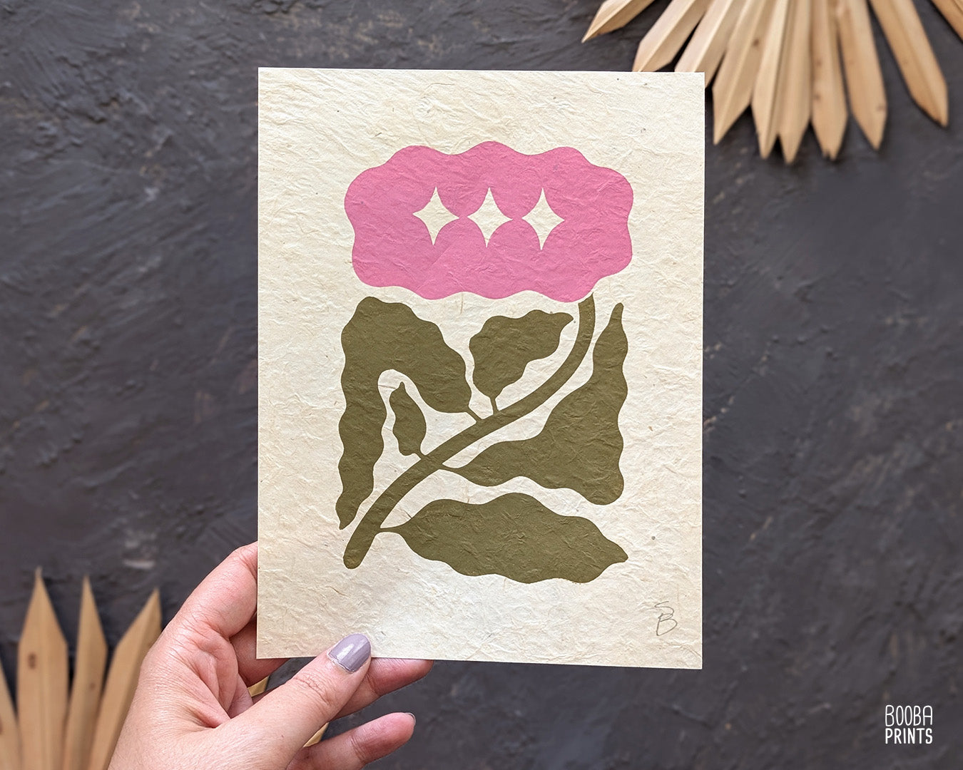 Minimalist mini linocut print of a hand carved flower, printed in soft green and pink ink on white paper, handmade botanical wall art. Cozy house warming gift. Art by Booba Prints