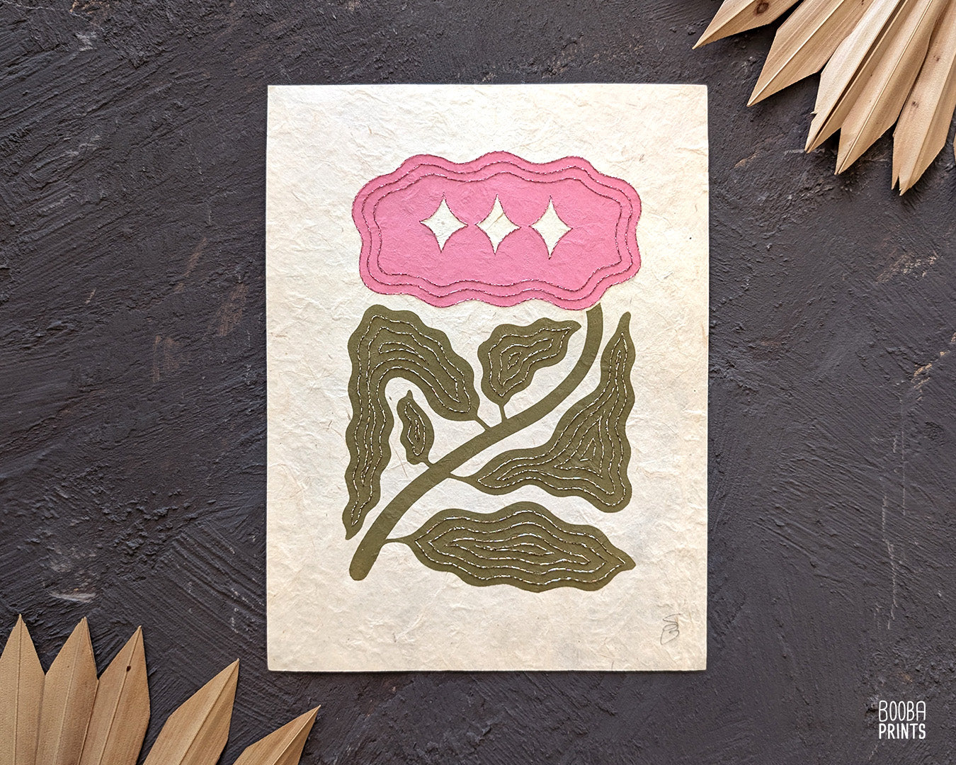 Hand embroidered linocut print. A unique linocut print of a minimal stylized flower, printed by hand in pink and green oil based ink, and hand embroidered with champagne and pink embroidery thread