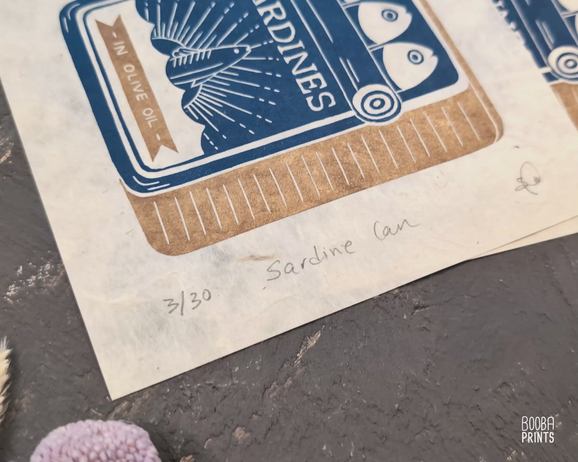 Original handmade linocut prints of Sardine Tin Can. Printed in blue and gold, using oil based ink on natural Lokta paper. Cute print for kitchen, stylized sardine print. Art by Booba Prints.