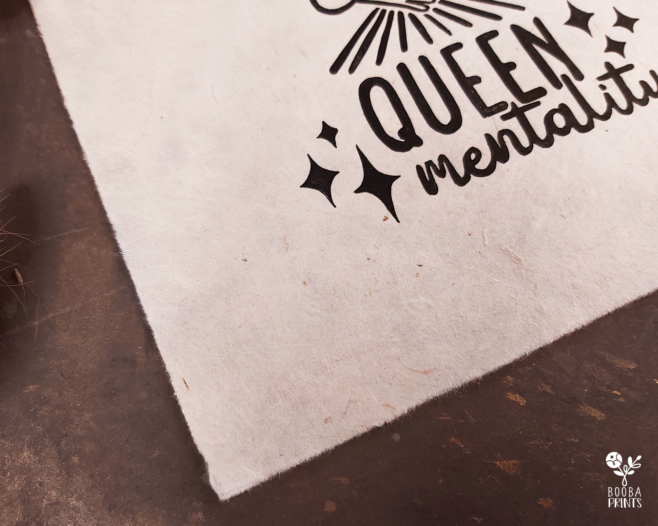 Handmade linocut print of Queen Mentality. Stylized illustration of a queen hugging herself and the text queen mentality. Printed with black or gold oil based ink on natural or Hosho paper. Empowering print for home decor. Super Seconds Festival, sale of samples and seconds. Artwork by Booba Prints.