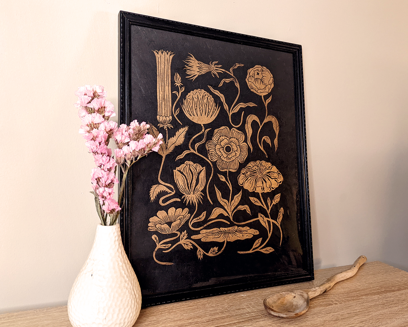 Framed picture of handmade and original linocut floral print. Floral composition printed in metallic gold on black Lokta paper. Flower love gift. Floral print by Booba Prints. Art by Booba Prints