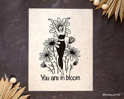 Handmade linocut print of Daisy Girl with the text "You Are In Bloom". Self love and self care print. Super Seconds Festival. Sale of seconds and samples. Original artwork in reduced price. Art by Booba Prints.