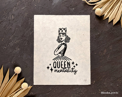 Handmade linocut print of Queen Mentality. Stylized illustration of a queen hugging herself and the text queen mentality. Printed with black or gold oil based ink on natural or Hosho paper. Empowering print for home decor. Super Seconds Festival, sale of samples and seconds. Artwork by Booba Prints.