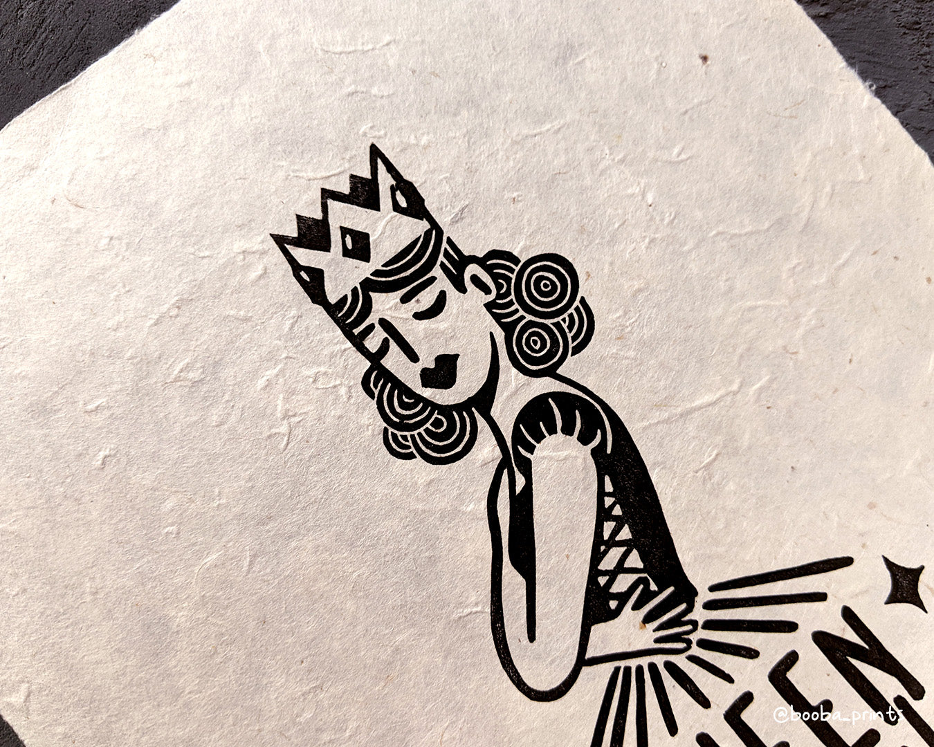 Handmade linocut print of Queen Mentality. Stylized illustration of a queen hugging herself and the text queen mentality. Printed with black or gold oil based ink on natural or Hosho paper. Empowering print for home decor. Super Seconds Festival, sale of samples and seconds. Artwork by Booba Prints.