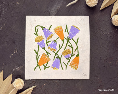 Handmade linocut print in the theme of Flora and Fauna. Floral print in 4 colors orange, purple green and gold. Printed with oil based ink and finished with metallic paint. Art by Booba Prints.