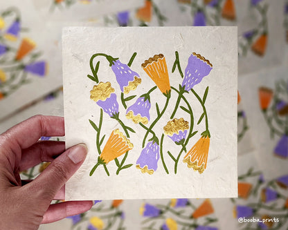 Handmade linocut print in the theme of Flora and Fauna. Floral print in 4 colors orange, purple green and gold. Printed with oil based ink and finished with metallic paint. Art by Booba Prints.