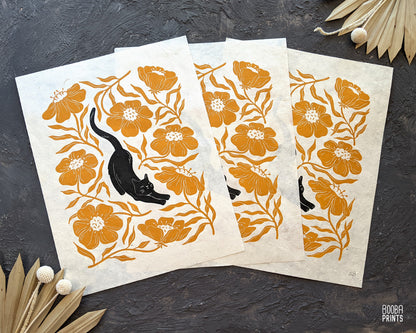 Handmade original linocut print of Stretchy Cat, a black cat and orange flower linocut print. Gift for cat lover or a flower lover. Housewarming gift. Mother's Day gift. Artwork for home decor. Gallery wall print. Art by Booba Prints